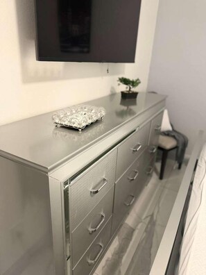 A modern, metallic dresser with drawers and a flat-screen TV mounted above it. - Clean & Cozy 1-Bedroom • AC • Fast WiFi • Las Vegas (Las Vegas)