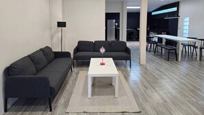 Un salon moderne comprenant un canapé, une table basse et un coin repas avec une table et des chaises.