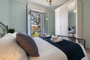 Ein Schlafzimmer mit Bett, Balkon, Kleiderschrank und Spiegel.