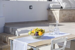 A table with a fruit bowl, two glasses, and a vase. - [NEW] J & I Rooftop Retreat in a small village (89H2+F36 Karoti, Greece)