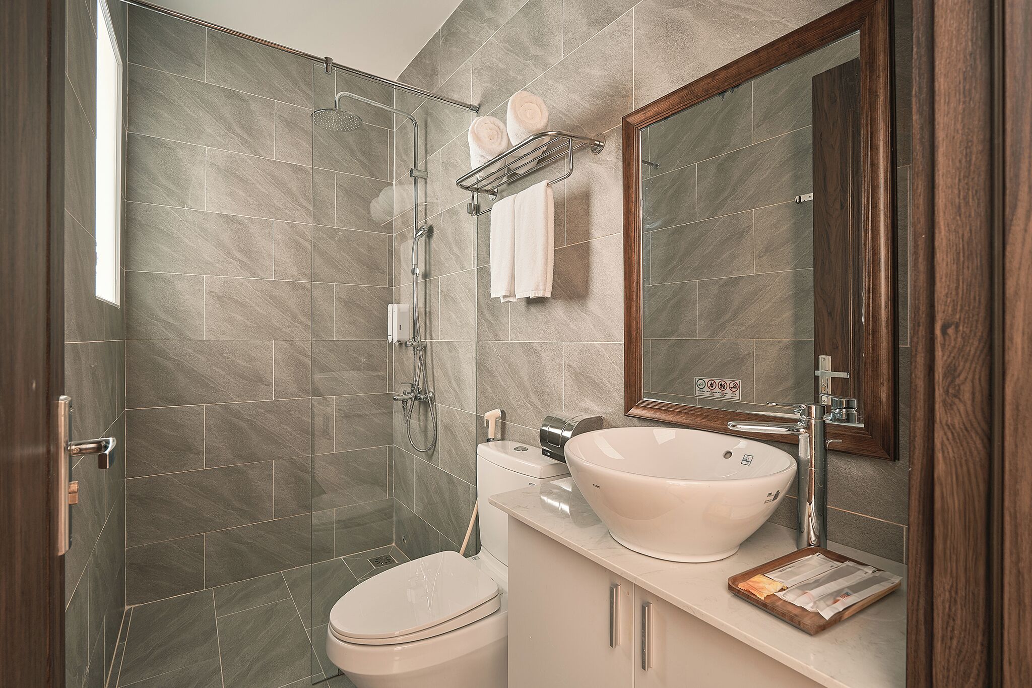 A modern bathroom with a shower, toilet, and sink.