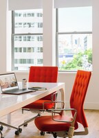 A modern office with a laptop, a can of Coca-Cola, and a notebook on a white table.