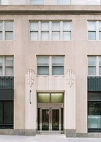 A building facade with a large entrance labeled 'ONE PLATT STREET,' featuring a symmetrical design with multiple windows and decorative elements.
