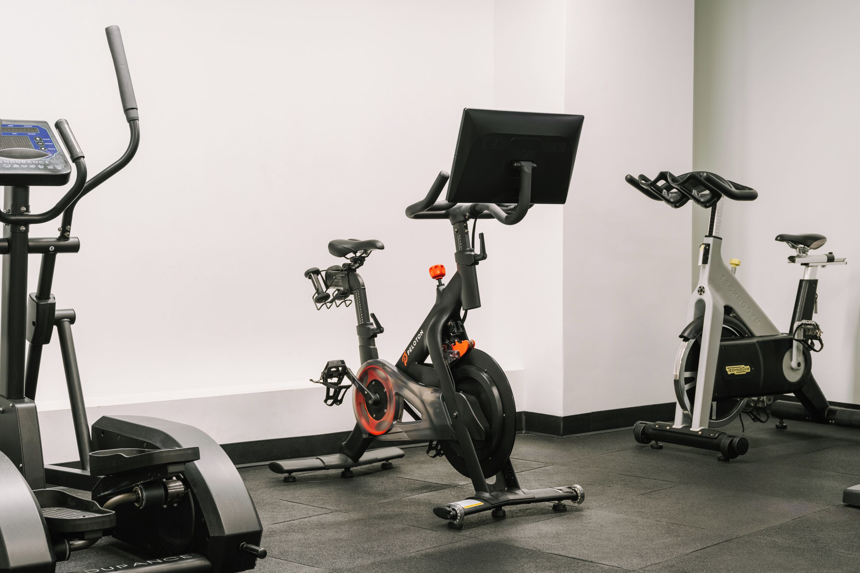 A gym with stationary bikes, a treadmill, and a rowing machine.