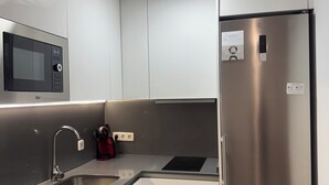 Una cucina moderna con elettrodomestici in acciaio inossidabile, tra cui forno a microonde, forno e frigorifero.