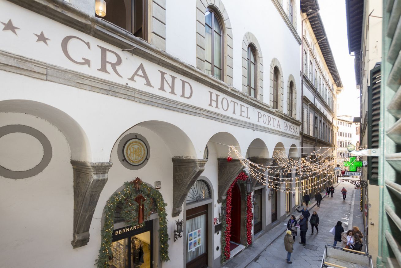 Fachada del Grand Hotel Porta Rossa con ventanas arqueadas y un letrero sobre la entrada.