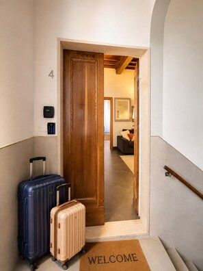 Ein Hotel Eingang mit Holztür, Fußmatte und zwei Koffer.