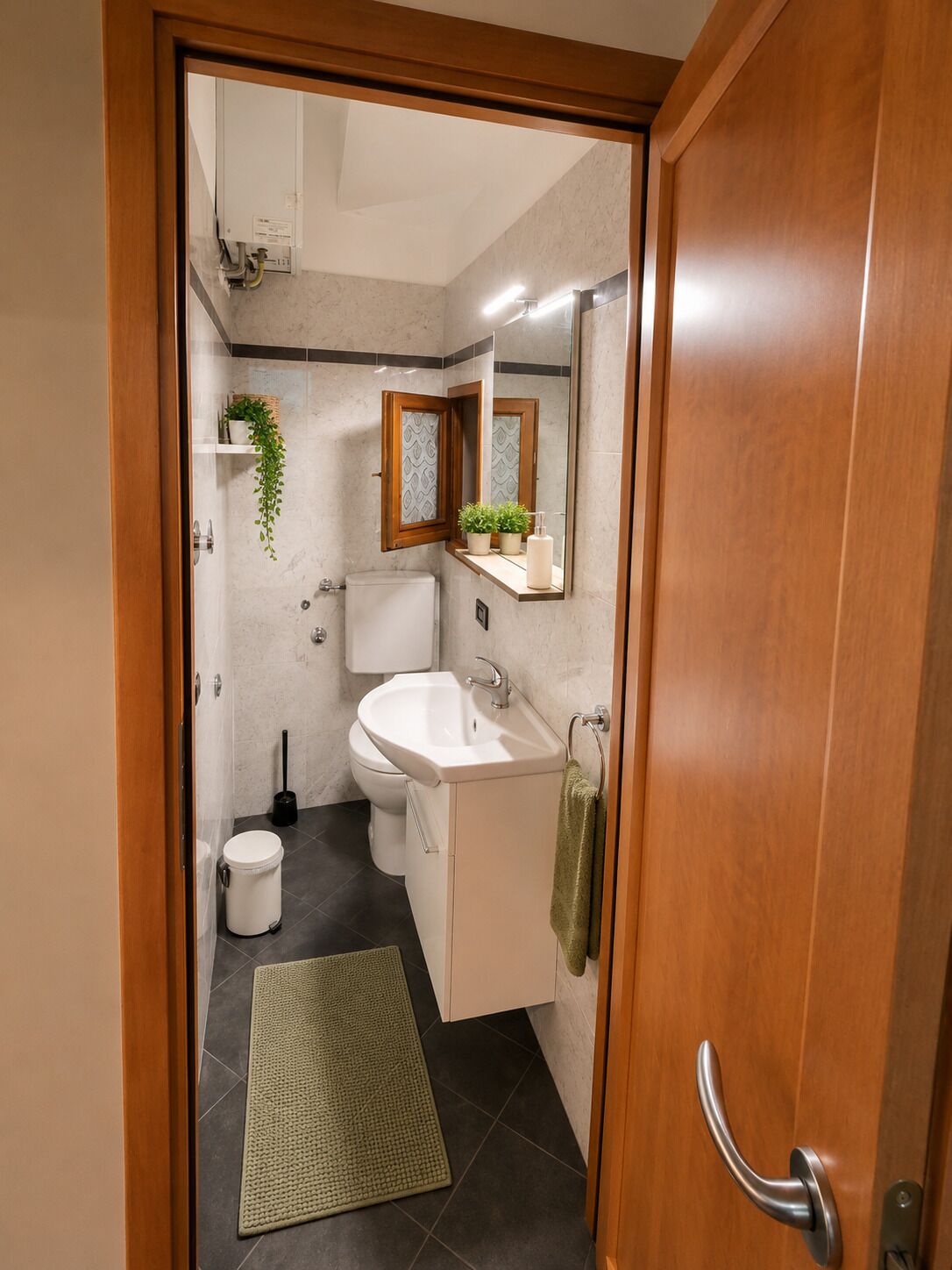 Un baño con inodoro, lavamanos y espejo.