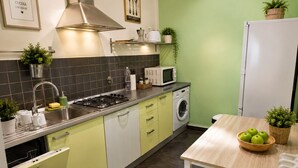 Uma cozinha moderna com fogão a gás, micro-ondas e máquina de lavar.