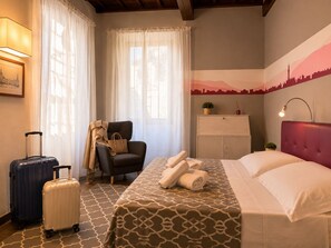 A hotel room with a bed, a chair, a desk, a lamp, and a window with curtains. - Red Door Dream Apartment 4 (Firenze)