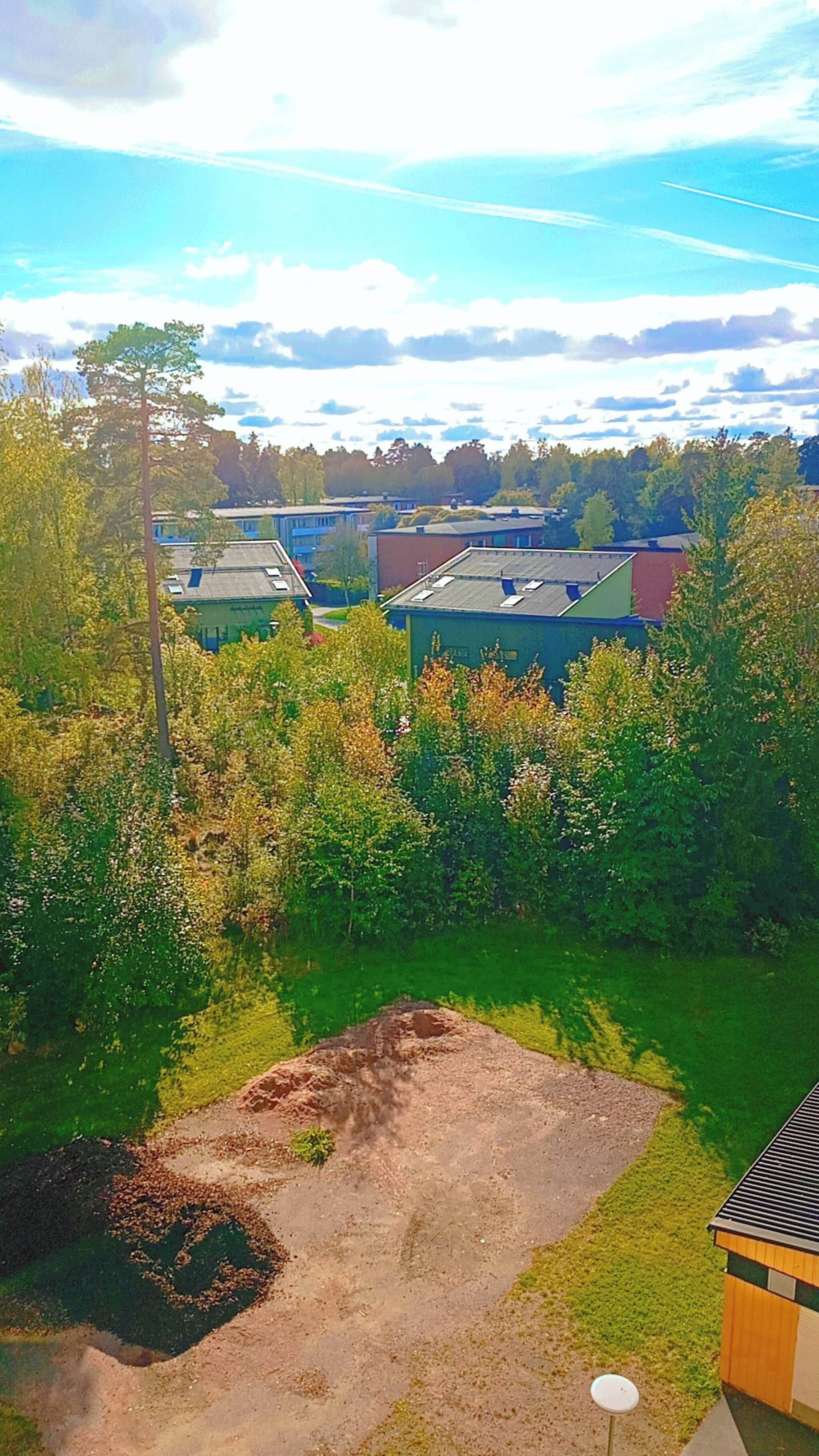 A residential area with houses, a grassy yard, and trees.