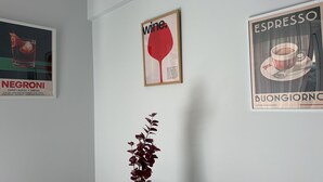 Drie ingelijste posters aan een muur: één voor Negroni, één voor wijn en één voor espresso.
