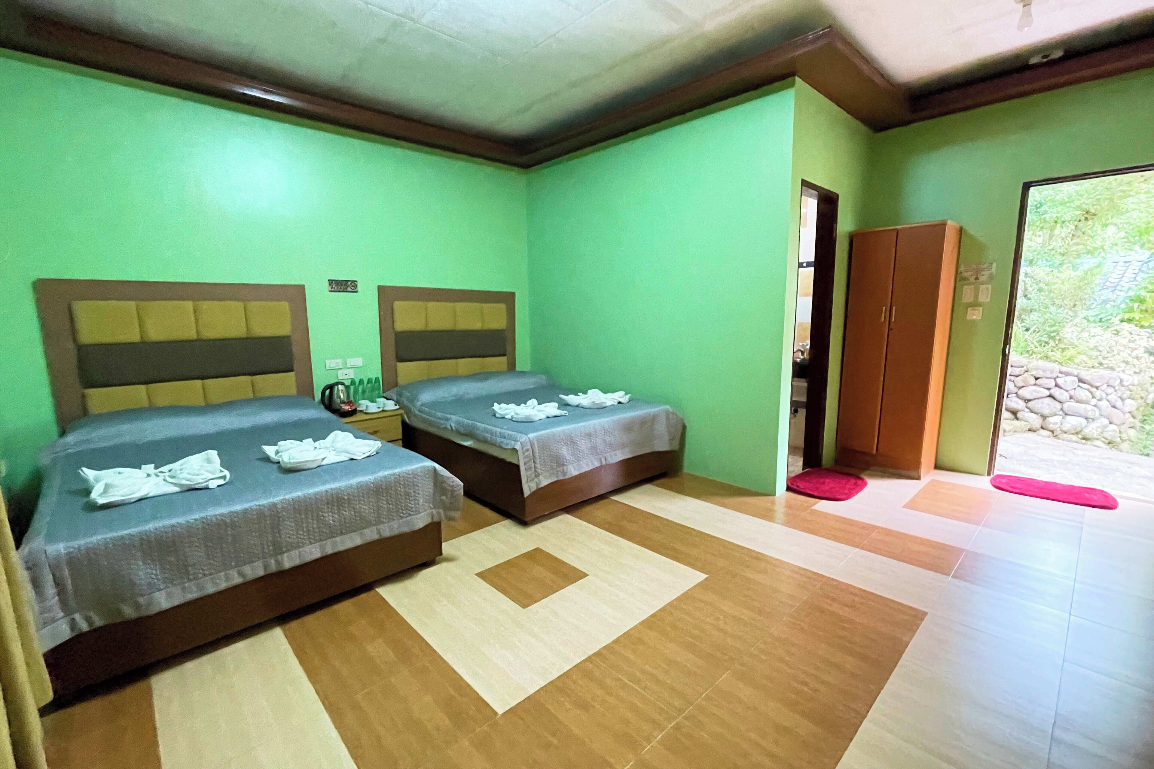 Una habitación con dos camas, un armario y una puerta que da al exterior.