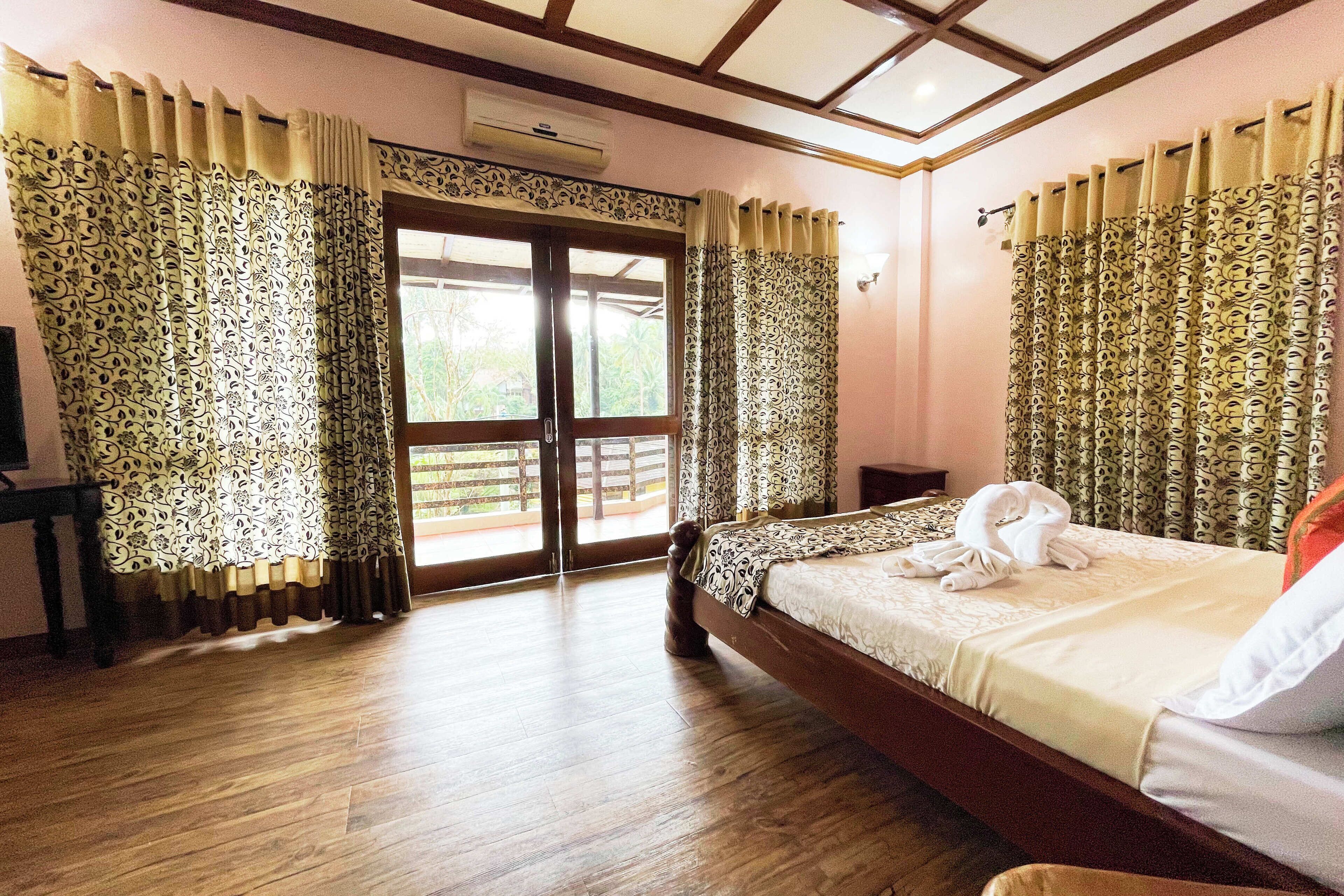 Un dormitorio con cama de madera, cortinas, una ventana y vistas al exterior.