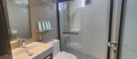 Une salle de bain moderne avec une douche à parois de verre, un lavabo blanc et des toilettes.