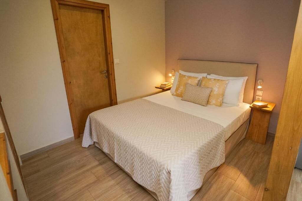 A neatly made bed with a patterned bedspread, two bedside lamps, and a wooden nightstand.