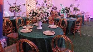 A banquet hall with round tables covered in green tablecloths, surrounded by golden chairs. - Oxygen Orbis Hotel (Ibadan)