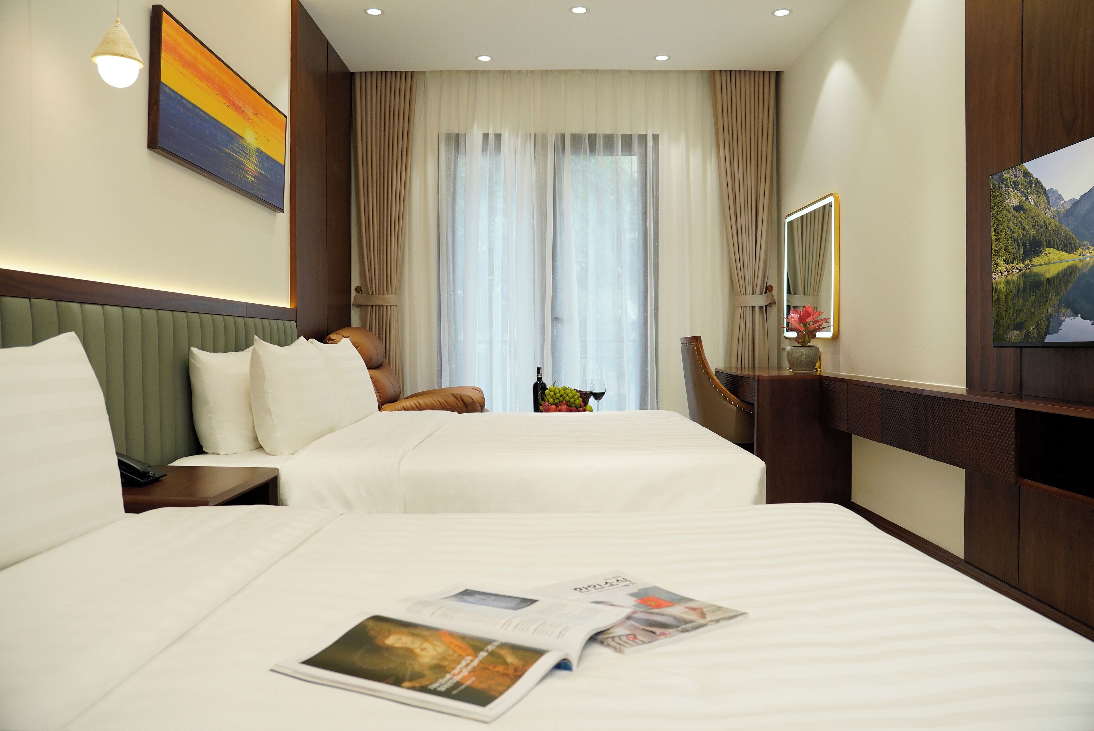 Habitación de hotel con dos camas, un ventanal con cortinas, un televisor de pantalla plana y un cuadro en la pared.