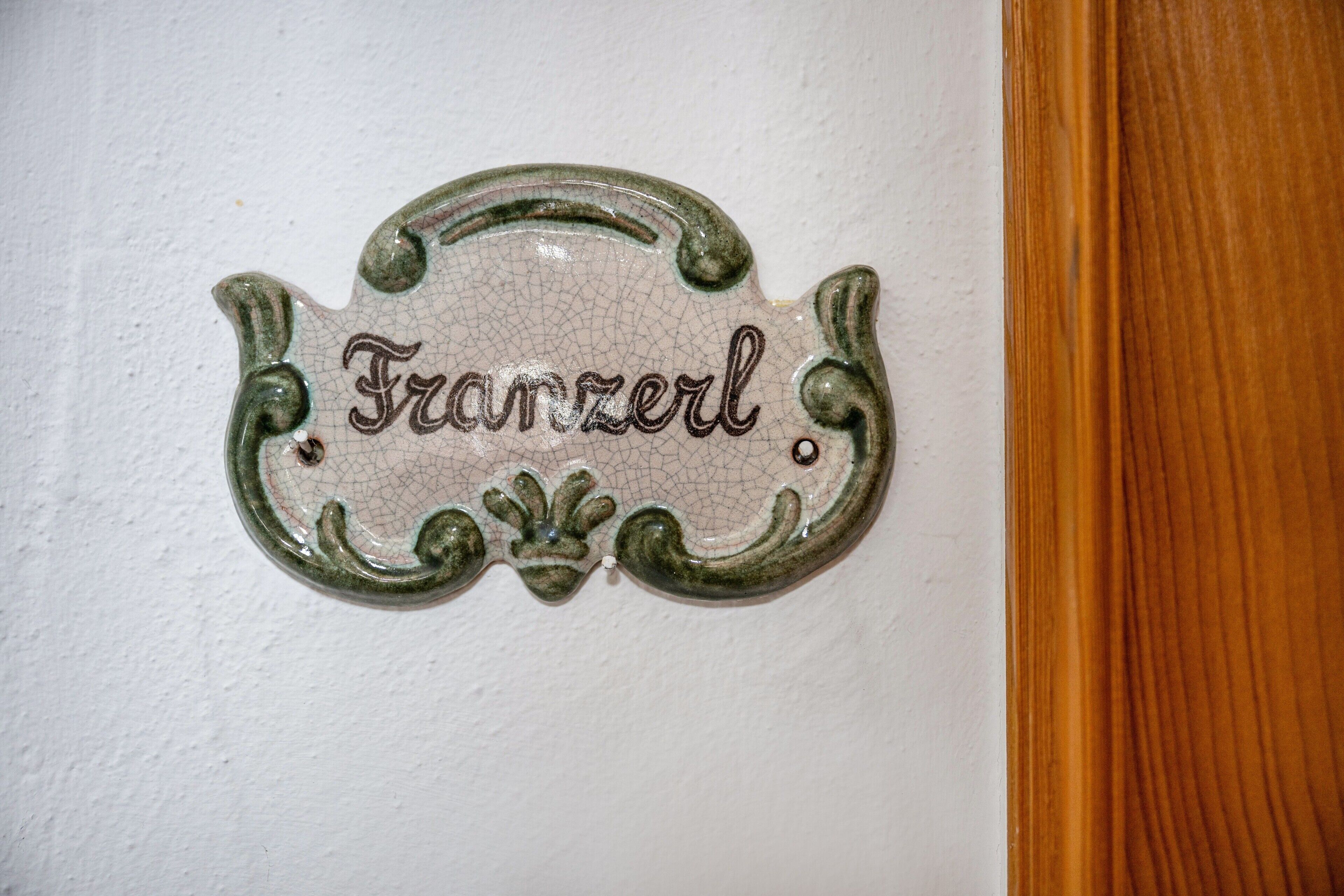A decorative sign with the word 'Franzerl' on a white wall.