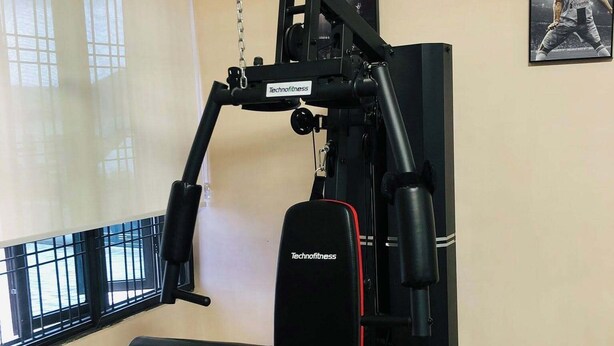 Ein Fitnessraum mit Langhantelbank, Squat-Gestell und Klimmzugstange.