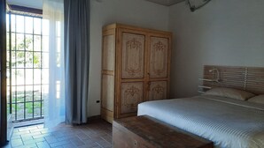 Une chambre à coucher avec un lit, une armoire en bois et un banc.