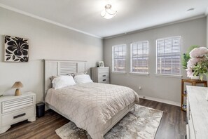 A bedroom with a bed, bedside tables, a nightstand, a dresser, and a window with blinds. - Executive 1BR in Oak Lawn, Courtyard, Work Space, Gated Community (Dallas)