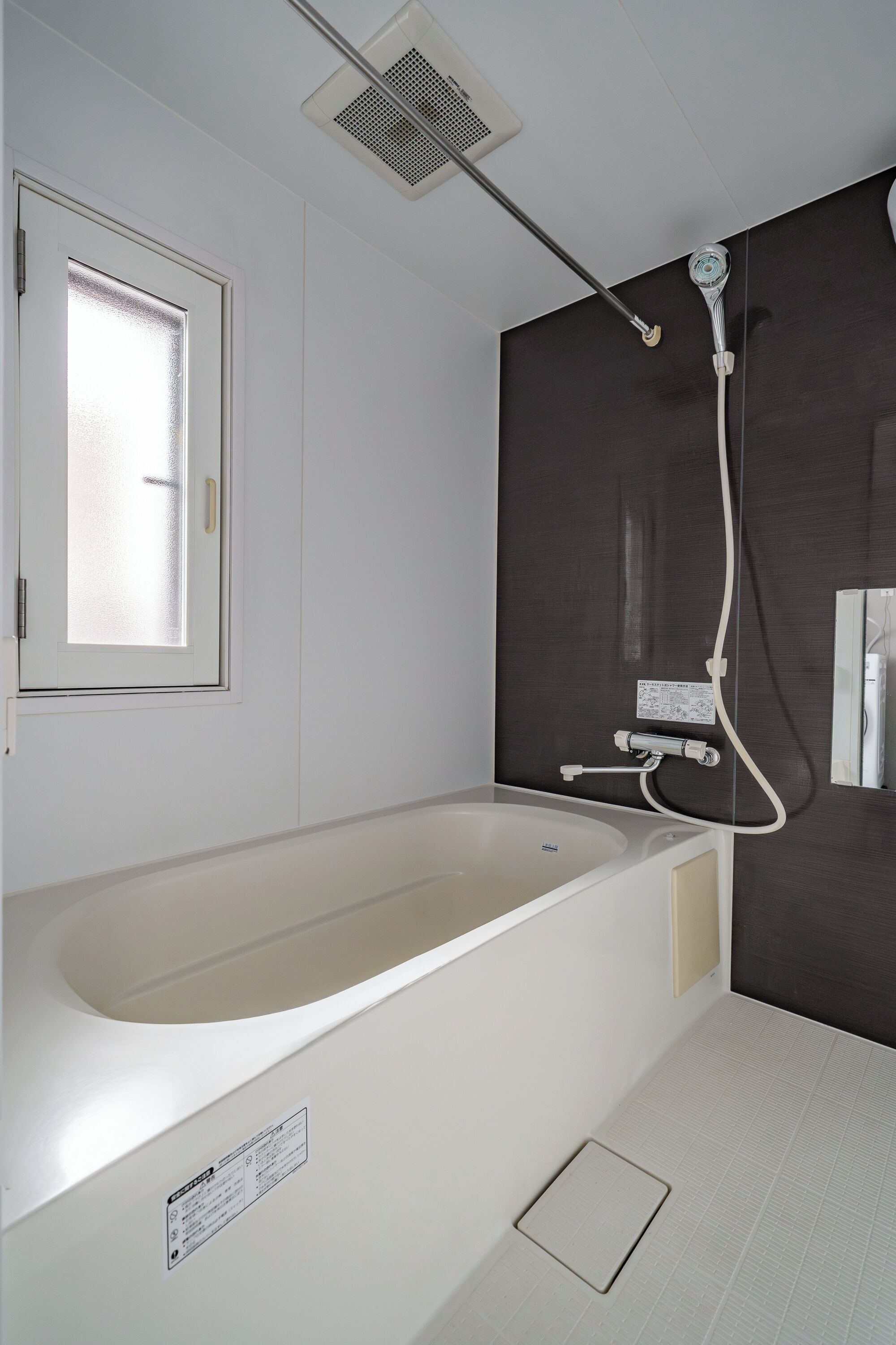 A bathroom with a bathtub, a shower, and a window.