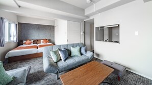 A modern hotel room with a large bed, a sofa, a coffee table, and a mirror on the wall. - MP STYLE SAPPORO-50 (Sapporo)