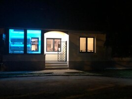 A building with a well-lit entrance, a visible door, and a window.