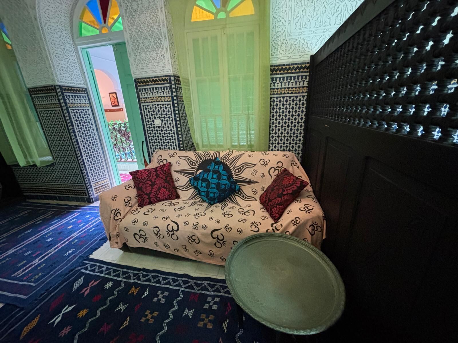 Una habitación tradicional con un sofá estampado, un cuenco decorativo y diseños intrincados en las paredes.