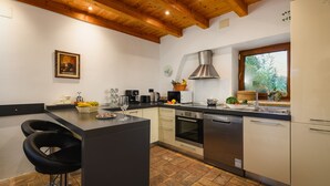 Una cocina moderna con una isla central, un área de comedor con dos sillas y un ventanal que ofrece vistas al exterior.