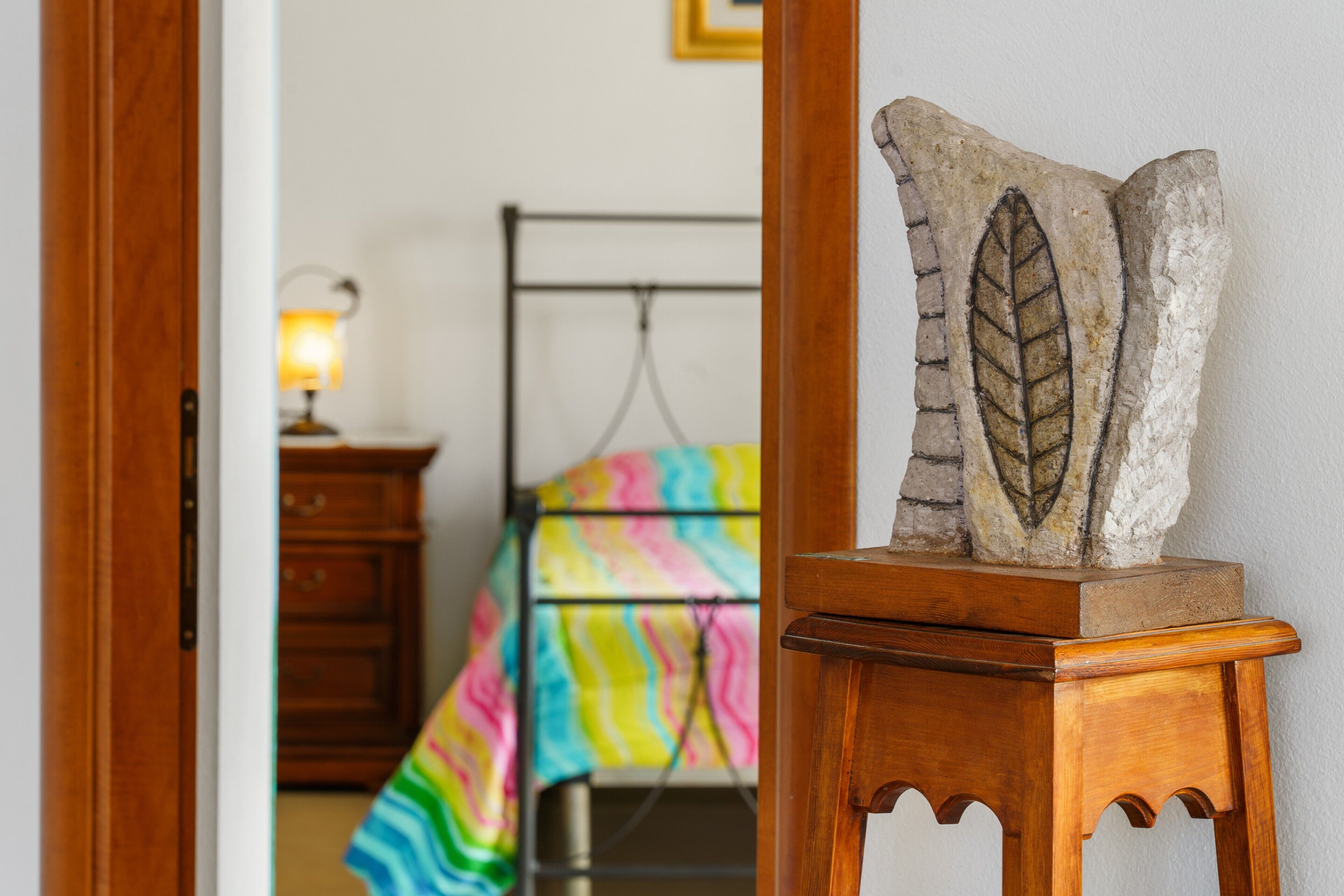 Une chambre à coucher avec un lit, une commode et une table de chevet.