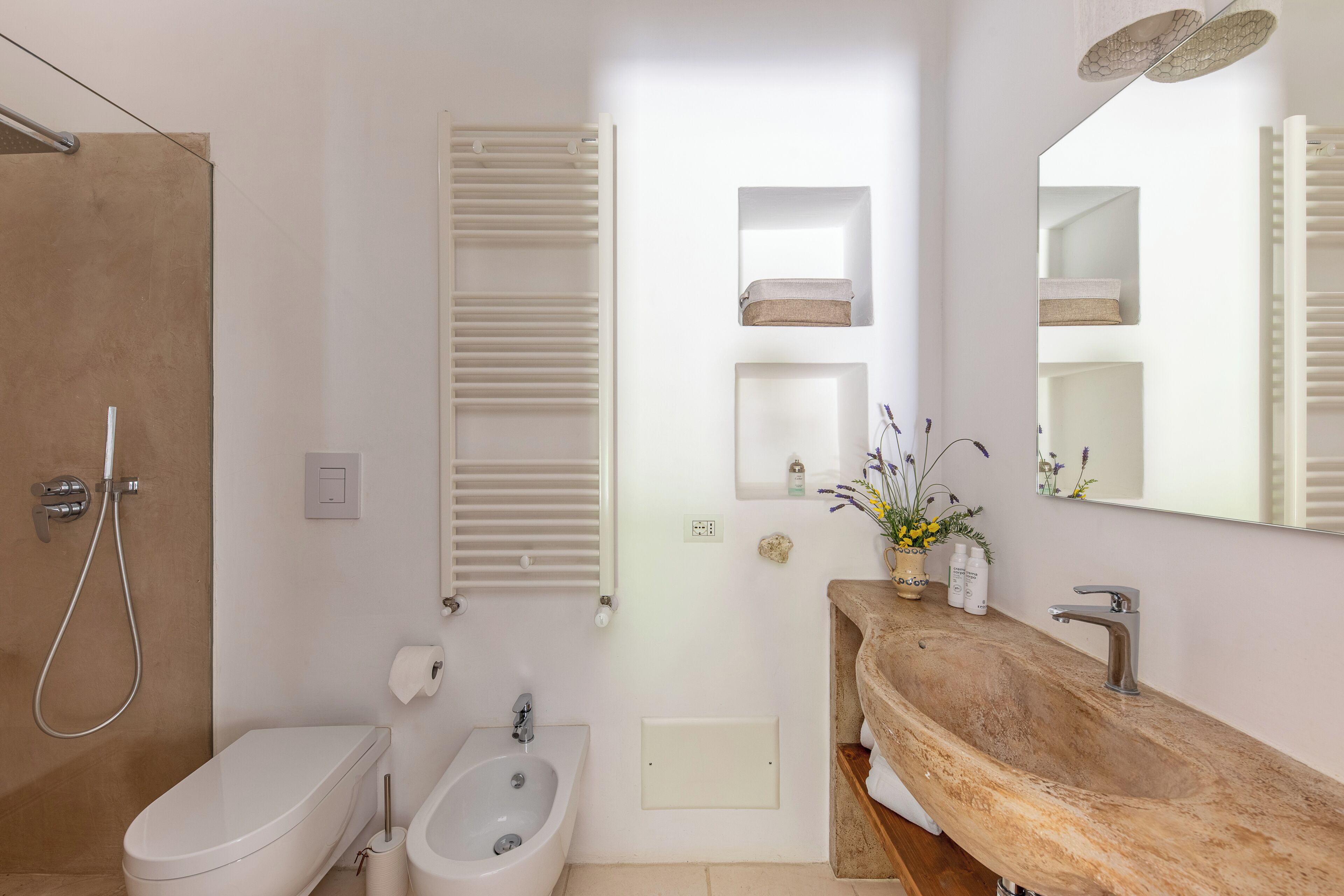 Un baño con ducha, bidé, lavabo y espejo.