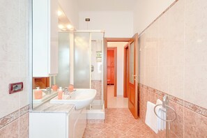 A modern bathroom with a large mirror, a sink, and a shower area. - SV - Moroni (Savona)