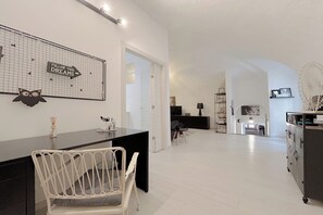 A modern, well-lit living area with a dining table, chairs, and a kitchen area in the background. - SV - Pia (Savona)