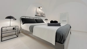 A modern bedroom with a bed, bedside tables, a wall-mounted light, and a mirror. - SV - Pia (Savona)