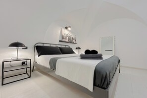 A modern bedroom with a bed, bedside tables, a wall-mounted light, and a mirror. - SV - Pia (Savona)
