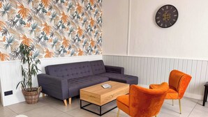 Ein modernes Wohnzimmer mit einer Couch, einem Couchtisch und zwei Sesseln.