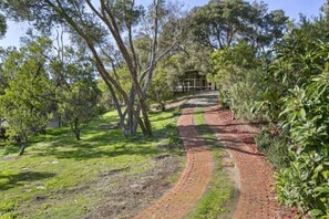 A brick pathway leading to a wooden structure surrounded by trees. - The Moonah Beach Shack (Rye)