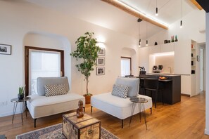 A modern living room with a sofa, a coffee table, and a dining area with chairs. - The Space Arena@100m (Verona)