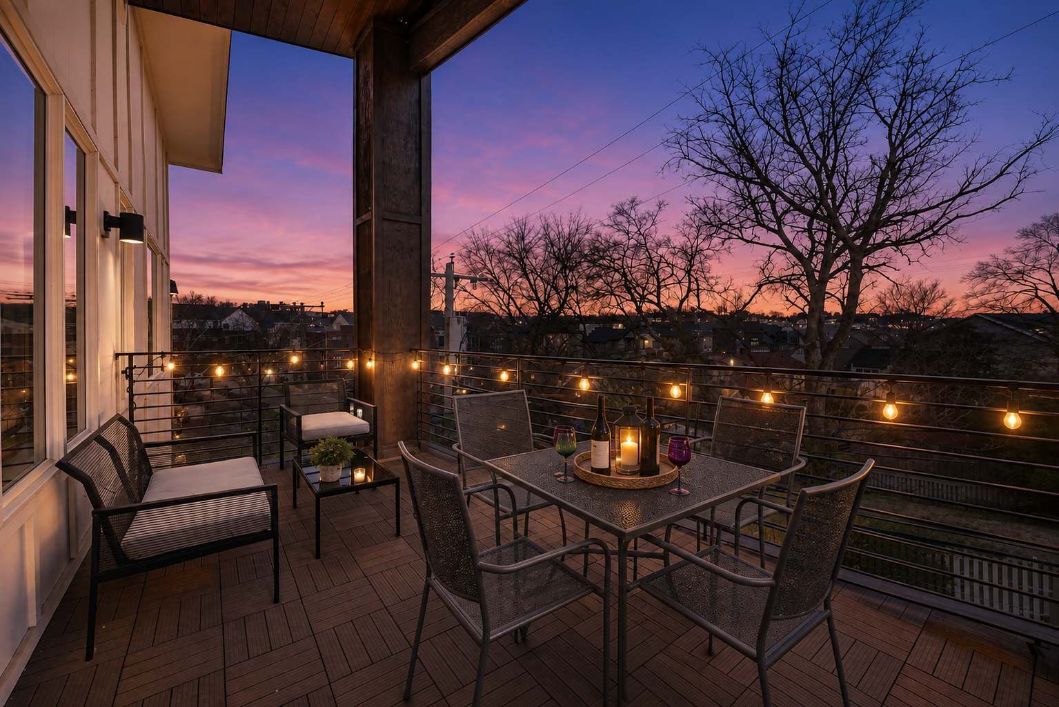 An outdoor patio with a table set for dining, surrounded by chairs, and string lights.