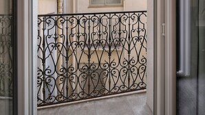 A view from a balcony with a wrought iron railing, a potted plant, and a building with a window and air conditioning unit in the background. - 2 PIECES MODERN FELIX FAURE A1B232 (Cannes)