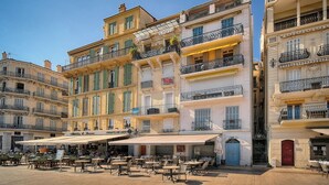 A historic building with multiple balconies, outdoor seating, and a café. - 2 PIECES MODERN FELIX FAURE A1B232 (Cannes)
