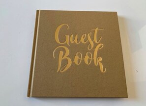 A brown book titled "Guest Book" with gold embossed lettering. - 🏆 T4 NEUF CENTRE-VILLE - 3 CHAMBRES - LIONS DE CANNES 2026 5 mn des Plages (Cannes)