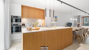 Una cocina moderna con armarios de madera, una isla central y electrodomésticos integrados.