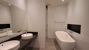 A modern bathroom with two sinks, a large bathtub, and a mirror. - วิลลาพร้อมสระว่ายน้ำ 4 ห้องนอน 4 ห้องน้ำ พร้อมสิ่งอำนวยความสะดวก (Tambon San Phak Wan)