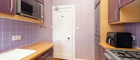 A compact kitchen with a microwave, toaster, and stove.
