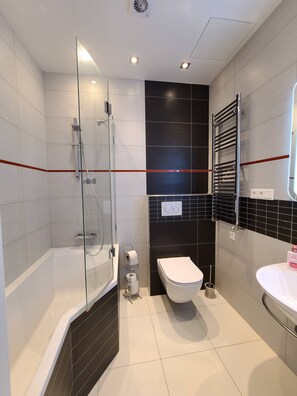 A modern bathroom with a glass-enclosed shower, a white toilet, and a sink with a mirror. - Prague Centre Apartments - Apartment B (Prague)