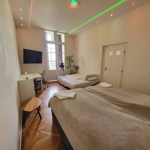 A modern hotel room with two beds, a desk, a chair, and a TV. - Prague Centre Apartments - Apartment B (Prague)