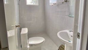 A small, modern bathroom with a toilet, sink, and shower. - Ferm's Residence B-spacious Apartment With Fast Wifi (Dauis)